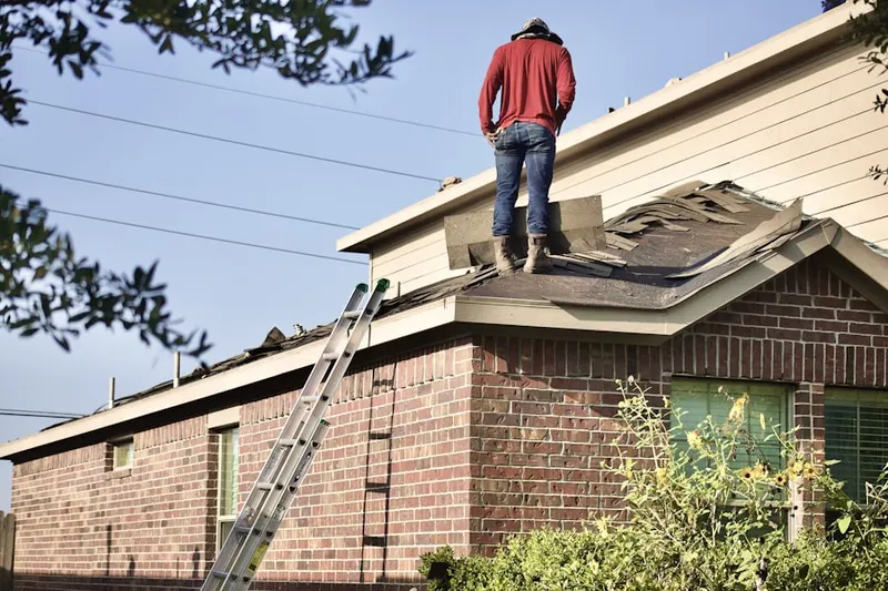 Professional roofer working on a residential roof in Merriam
